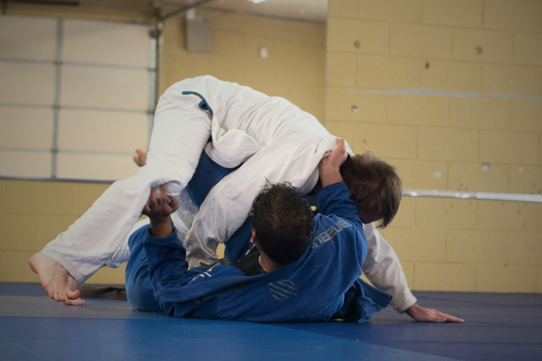 Two athletes grappling on a mat