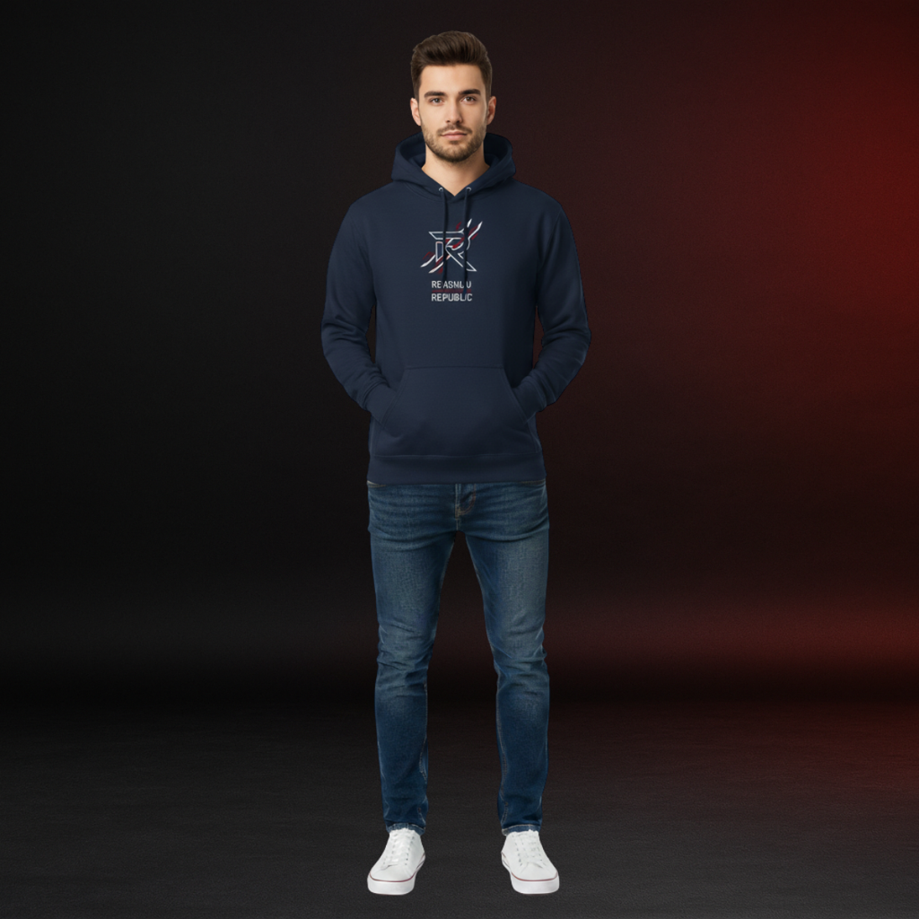 Man wearing a navy hoodie with a logo and text, standing against a dark background