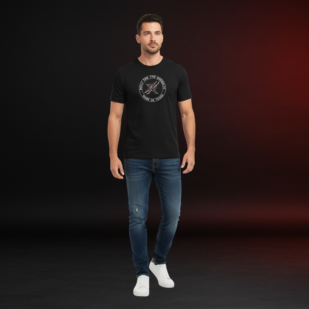 Man wearing a black t-shirt with a logo and blue jeans on a dark background