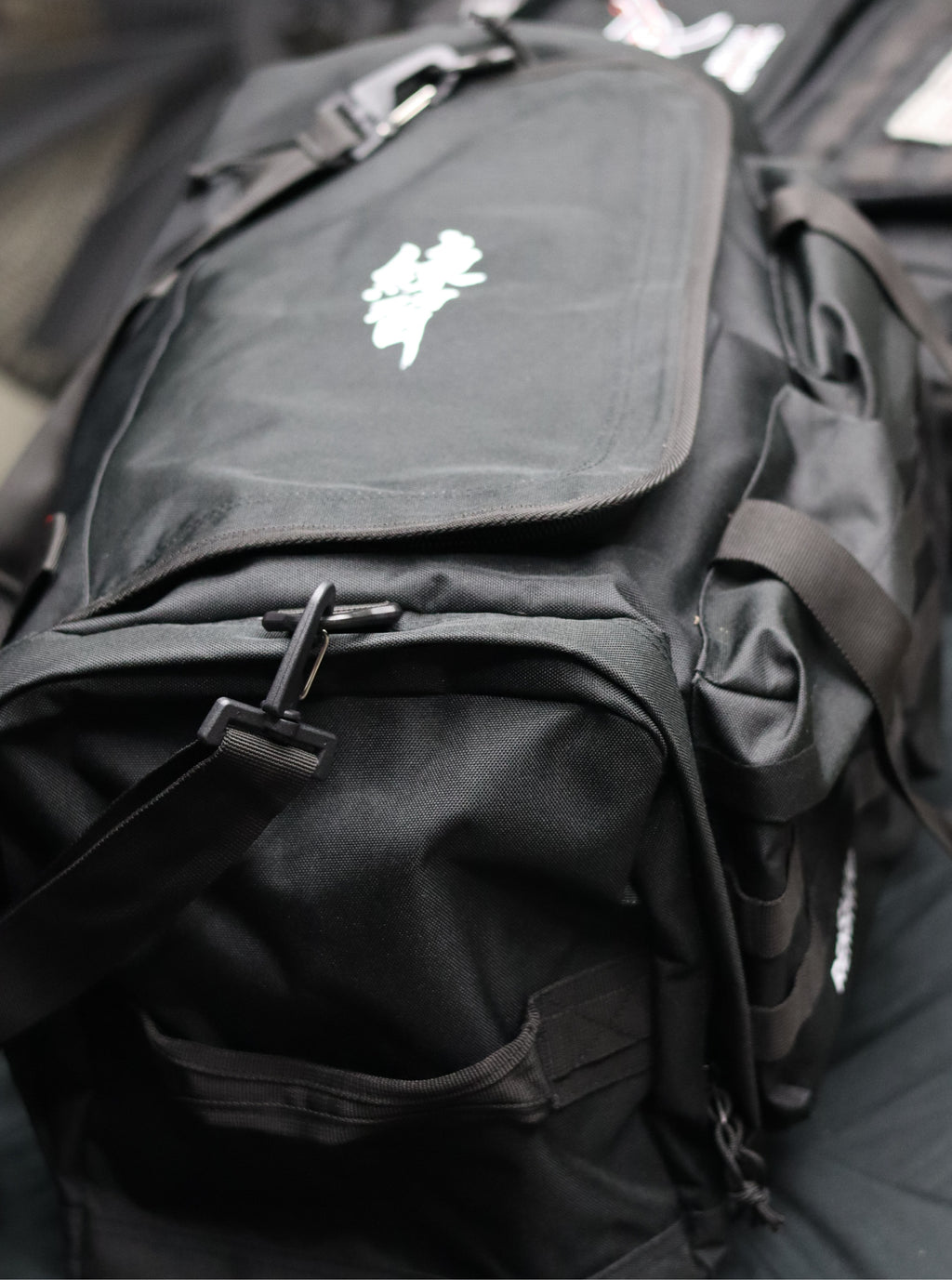 Black backpack with a white logo on a blurred background
