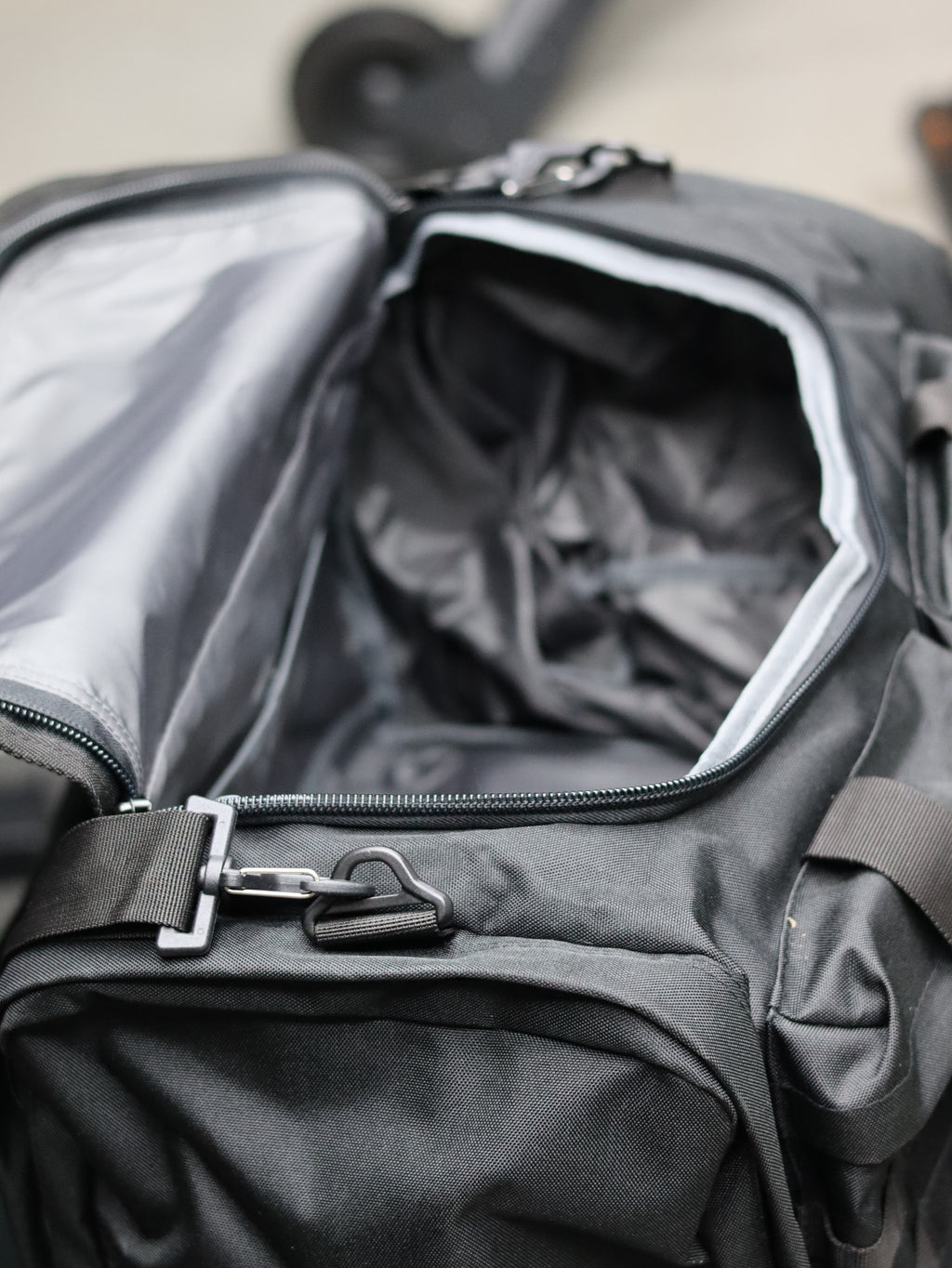 Close-up of a black backpack with a zipper, showing the interior.