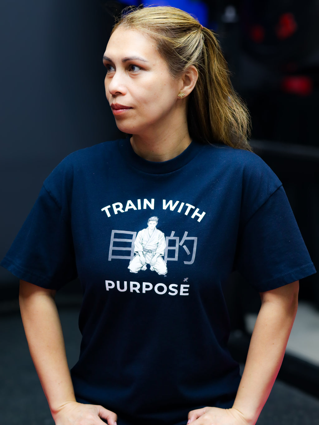 Person wearing a navy blue t-shirt with motivational text and graphic