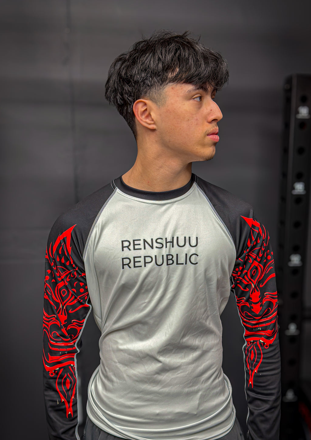 Person wearing a 'Renshuhu Republic' shirt with red designs on a dark background