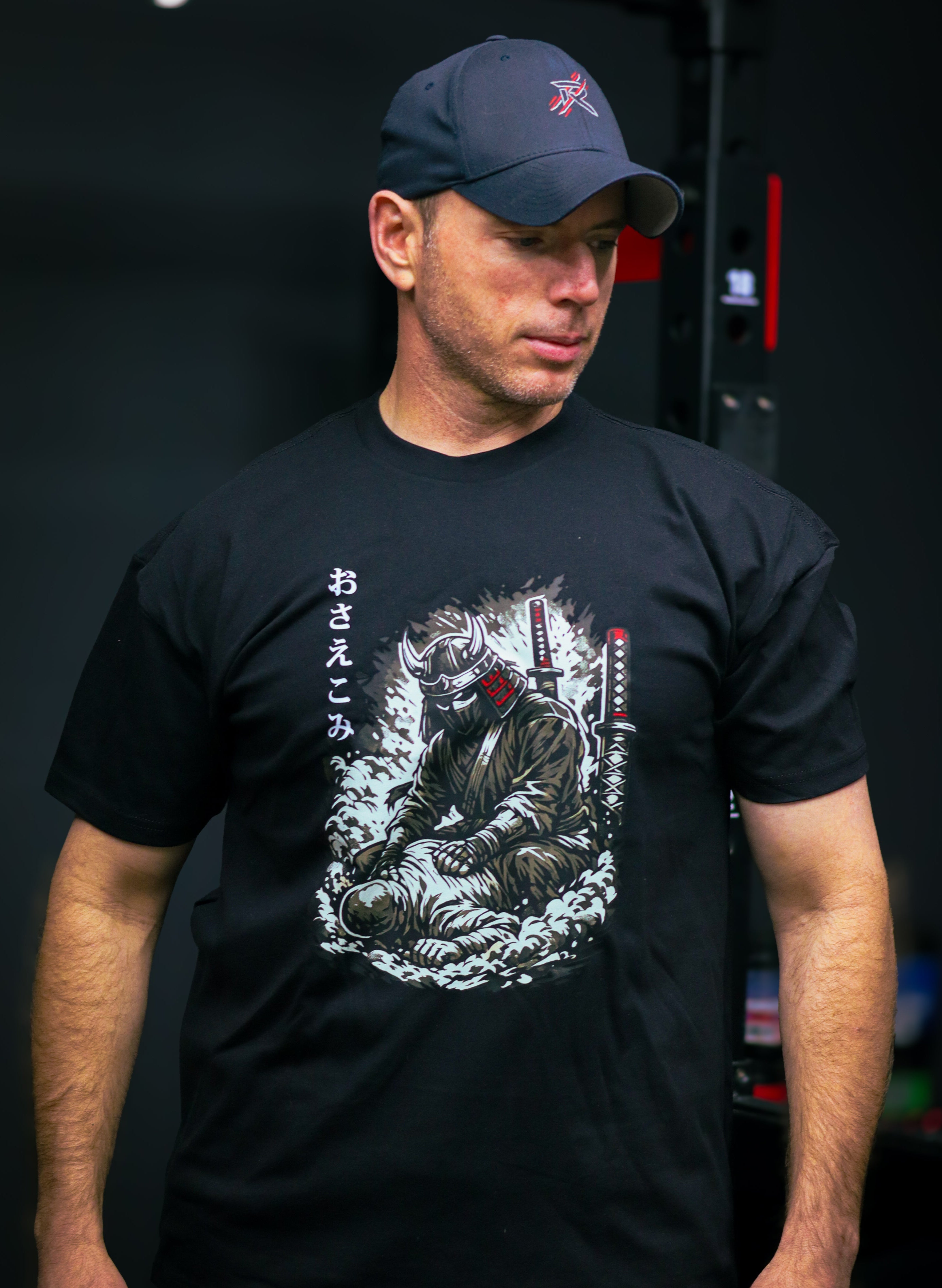 man wearing a black shirt with a graphic of a samurai