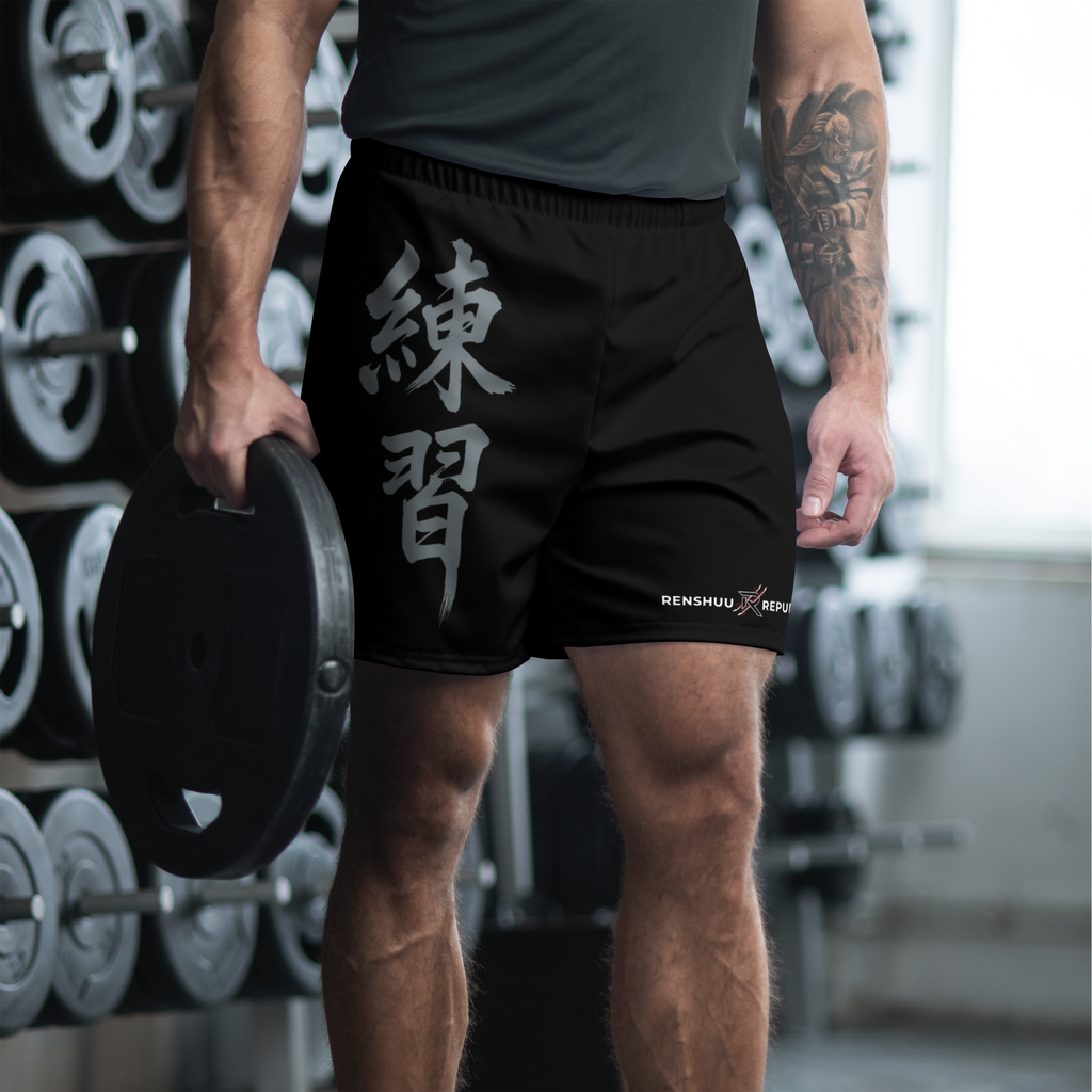 Person wearing black shorts with white text in a gym setting